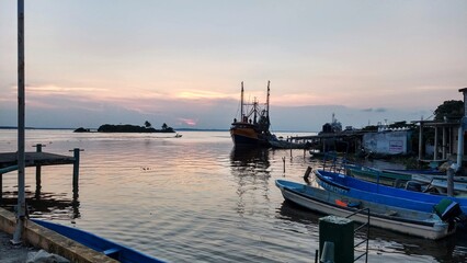 Fototapeta premium sunset seen from the port of alvarado with fishing boats in the background