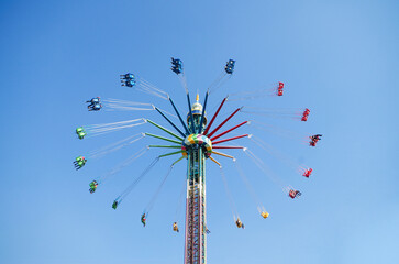 Swing ride spinning at high altitude in blue sky
