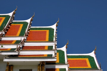 Buddhist temple`s roofs soar into blue sky