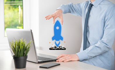Startup business concept, Businessman holding tablet and icon rocket is launching and soar flying...