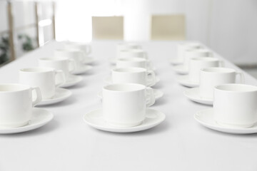 Many empty cups on white table indoors for coffee break