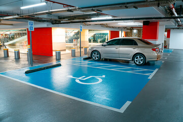 Interior of the new underground garage and a modern building construction with parking places for disabled.