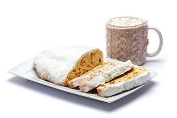 Sliced Traditional Christmas stollen cake with marzipan and dried fruit isolated on ceramic plate