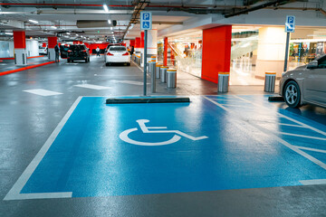 Interior of the new underground garage and a modern building construction with parking places for disabled.