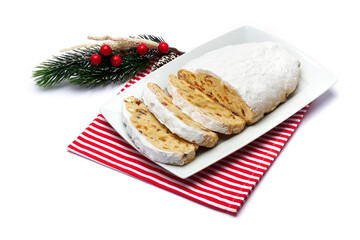 Sliced Traditional Christmas stollen cake with marzipan and dried fruit isolated on ceramic plate