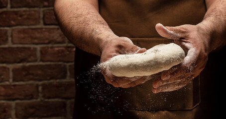 Clap hands of baker with flour. Beautiful and strong men's hands knead the dough make bread, pasta or pizza. Powdery flour flying into air