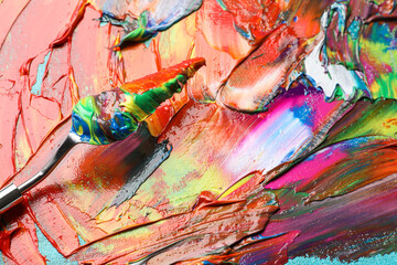 Mixed colorful acrylics and painting knife on canvas, closeup view
