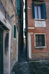 Fototapeta na wymiar Detail of the Venetian houses with a very narrow alley. Fondamenta S. Giobbe, Venice, Italy. Vertical image.