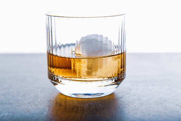Sphere shaped ice cube and close up whiskey view from studio.
