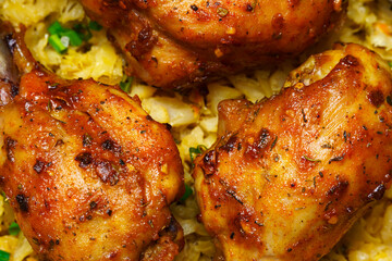 fried chicken legs in a frying pan with stewed chopped cabbage, cooked food in a rustic style as a background