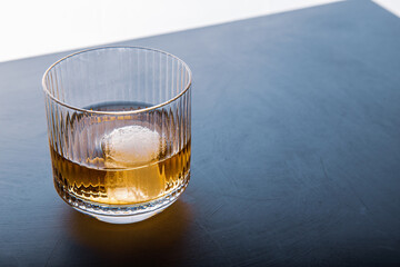 Sphere shaped ice cube and close up whiskey view from studio.