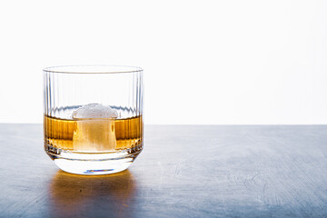 Sphere shaped ice cube and close up whiskey view from studio.