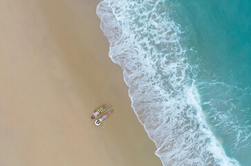 Aerial view of Relaxation the couple in the holiday with  sand beaches waves splashing on beach