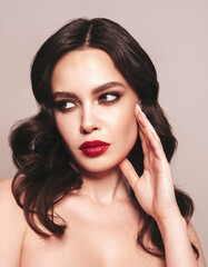 Beauty portrait of young brunette woman with evening makeup and perfect clean skin. Sexy model with curly hair posing in studio. With red bright natural lips. Isolated