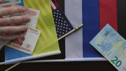 money euro dollar rubles banknotes American flag Russian flag Ukraine flag hands grabbing currency finance cash, consequence of military operation, loss, inflation, sanctions, global economy concept - Powered by Adobe