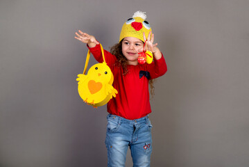 Little girl with a basket of eggs for the Easter holidays. Gray background for copying