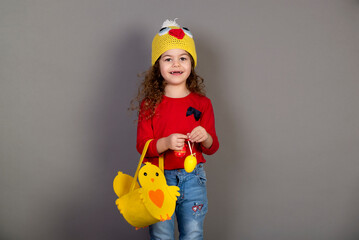 Little girl with a basket of eggs for the Easter holidays. Gray background for copying