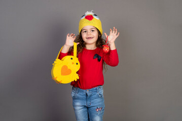 Little girl with a basket of eggs for the Easter holidays. Gray background for copying