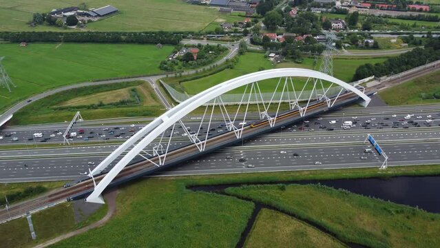 Aerial drone view of Zandhazenbrug is railway bridge with the longest span in the Netherlands located near Amsterdam and Muiderberg over the A1 motorway and part of the train line Weesp to Lelystad 4k