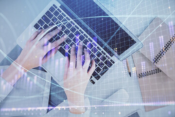 Double exposure of woman hands working on computer and forex graph hologram drawing. Top View. Financial analysis concept.