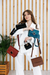 A few colorful stylish handbags. fashionable women's leather clutch bag. Traditional women's clutch bag with gold fittings made of fine colored leather. The girl in the frame. 