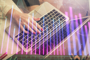 Double exposure of woman hands typing on computer and financial graph hologram drawing. Stock market analysis concept.