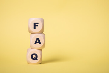 FAQ, Frequently Asked Questions Acronym on wooden cubes isolated on yellow background, copy space.