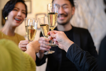 Image of a man and a woman toasting at a party, hand foreground blur, faceless, easy to use.