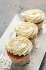 Obraz na płótnie Canvas Cupcakes or muffins with cream. Holiday cake celebration, delicious dessert, close up