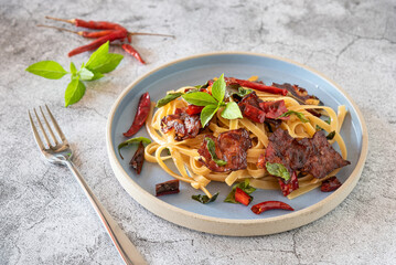 Closed up stir fired spicy spaghettis with crunch bacon for menu background