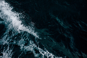 Fototapeta na wymiar splash on black background, Abstract blue ocean water with white foam background. Sea waves texture. Selective focus.