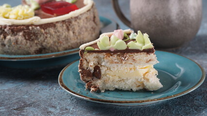 Piece of Kyiv cake with chocolate cream and decorated top on blue plate