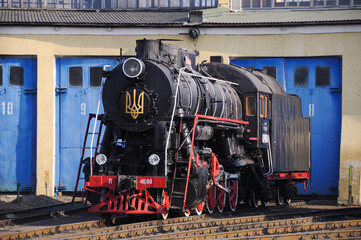 Vintage black steam locomotive. Old Soviet steam train in the depot. Space for text. Background with a steam train.