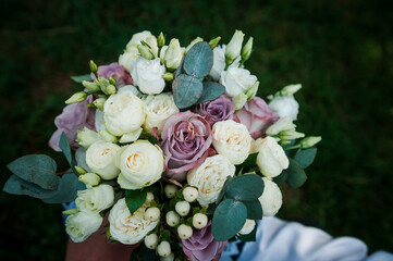 Beautiful bridal bouquet of flowers. Wedding rings on the bride's bouquet. Bridal bouquet close up