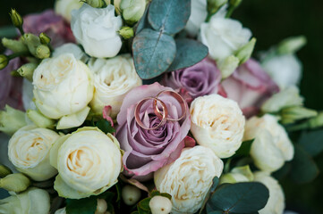 Beautiful bridal bouquet of flowers. Wedding rings on the bride's bouquet. Bridal bouquet close up