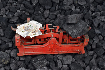  Polish currency and coal showed on weight as concept on coal of mine deposit mineral resources background