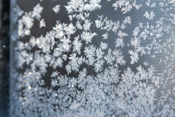 Old fashion window covered in frost with morning light shining thru the glass, dark contrast inside, shadows and light.