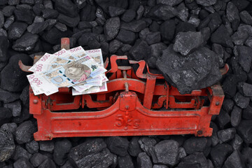  Polish currency and coal showed on weight as concept on coal of mine deposit mineral resources...