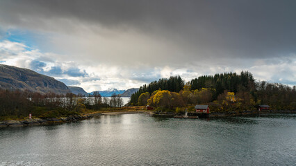 rotes Haus an der Küste von Norwegen bei Ørnes, an einer einsamen, ruhigen Stelle, umgeben von...