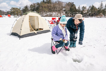 氷上でワカサギ釣りをする女の子　冬キャンプ