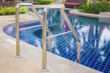 Ladder stainless handrails for descent into swimming pool.