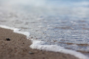 Fototapeta na wymiar wave splash sea beach macro, close up, Close up of sea foam and wet sand.