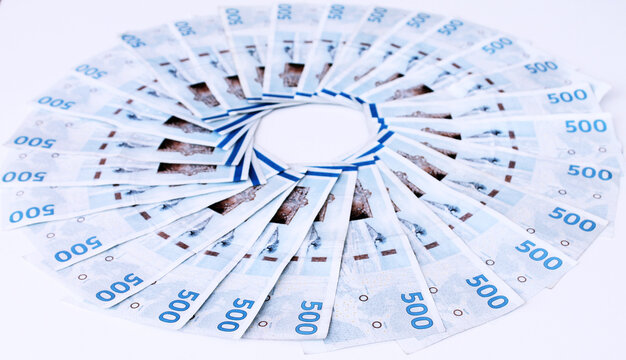 Danish kroner money bills placed in a circle on a white desk