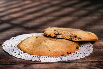 Homemade cookies with raisins, chocolate, nuts and milk on a wooden table and a art background with window light. Breakfast. Close up.