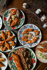 Traditional Turkish holiday Novruz spring holiday green semeni, traditional azerbaijan sweets, shekerbura, qogal, paxlava, mutaki and different nuts and sweets, top view, sweet stuff and Turkish sweet