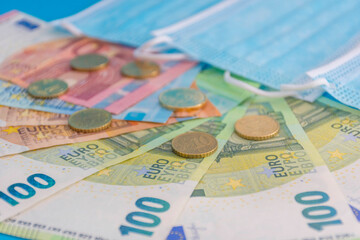 Medical masks and Euro currency banknotes. Financial crisis due to Coronavirus losses, selective...