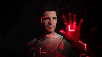 Modern technologies and human, concept. Portrait of a young man with a projection of red lines on his face, scanning or identification. Virtual Augmented Reality interfaces