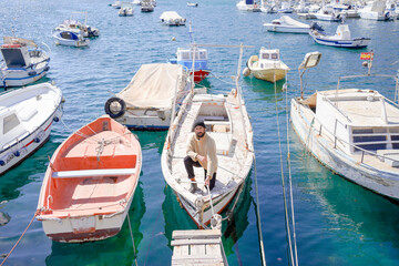 sailor man standing on the bow of a ship tying ropes