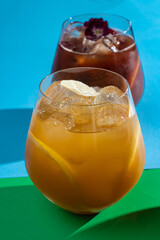 Sweet non-alcoholic fizz cocktail with lemon slices and beautiful flower on top, modern bright background