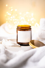 Natural wax candle in brown glass jar with metal lid and white empty clear sticker